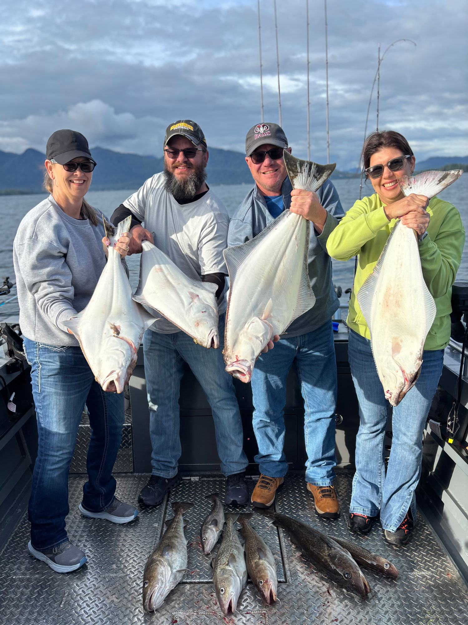 A group of four people holding large fish that they caught on the Ketchikan fishing trip.